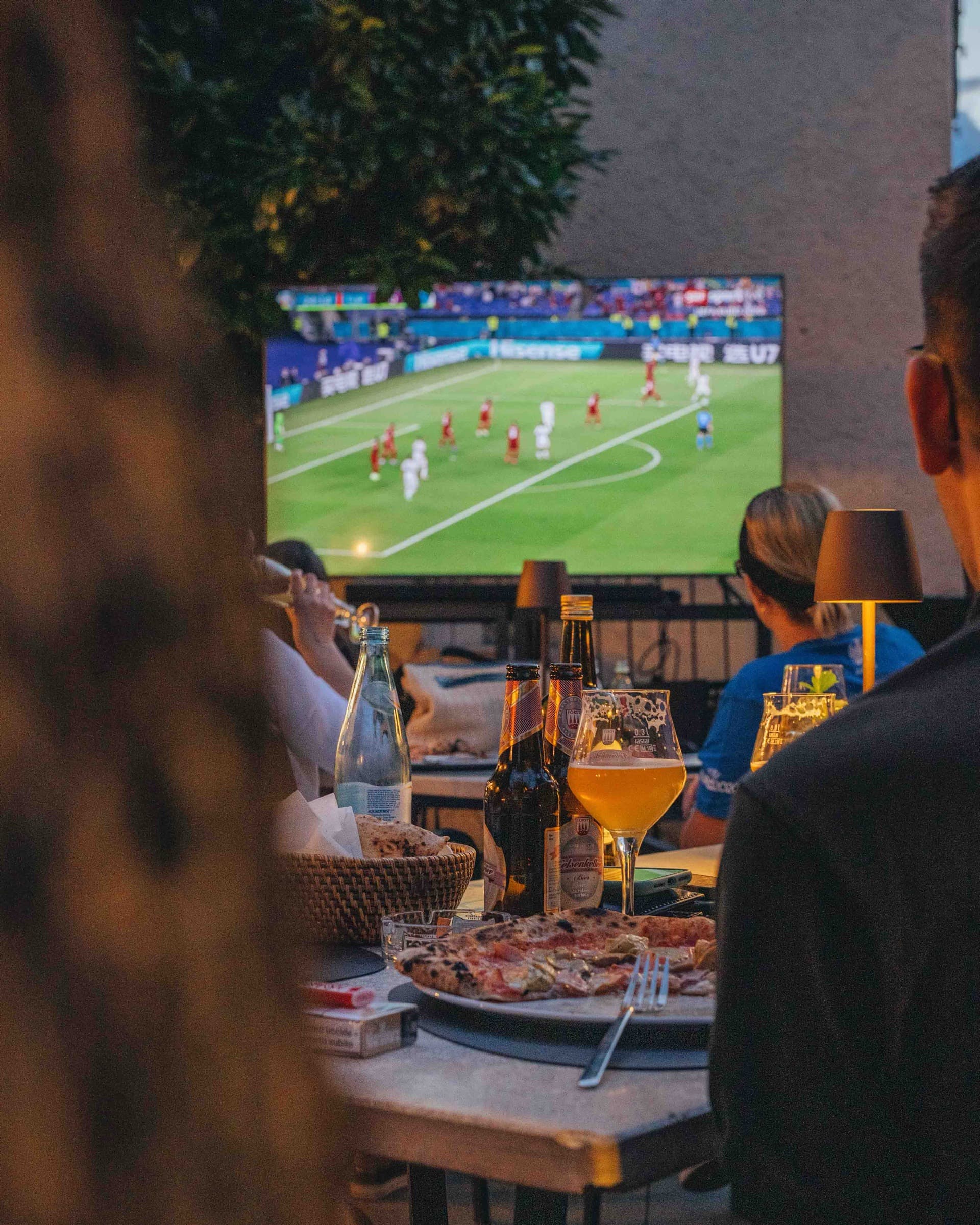 Pizza und Bier auf der Terrasse, ein Spiel auf dem Bildschirm